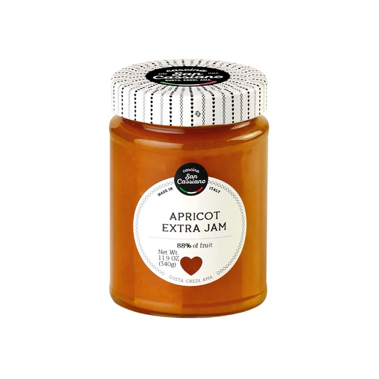 Jar of apricot extra jam with a decorative lid on a white background