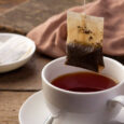 Close up Tea bag,Black tea in white cup on wooden table